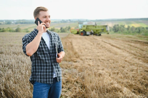 farmer on phone standing in field